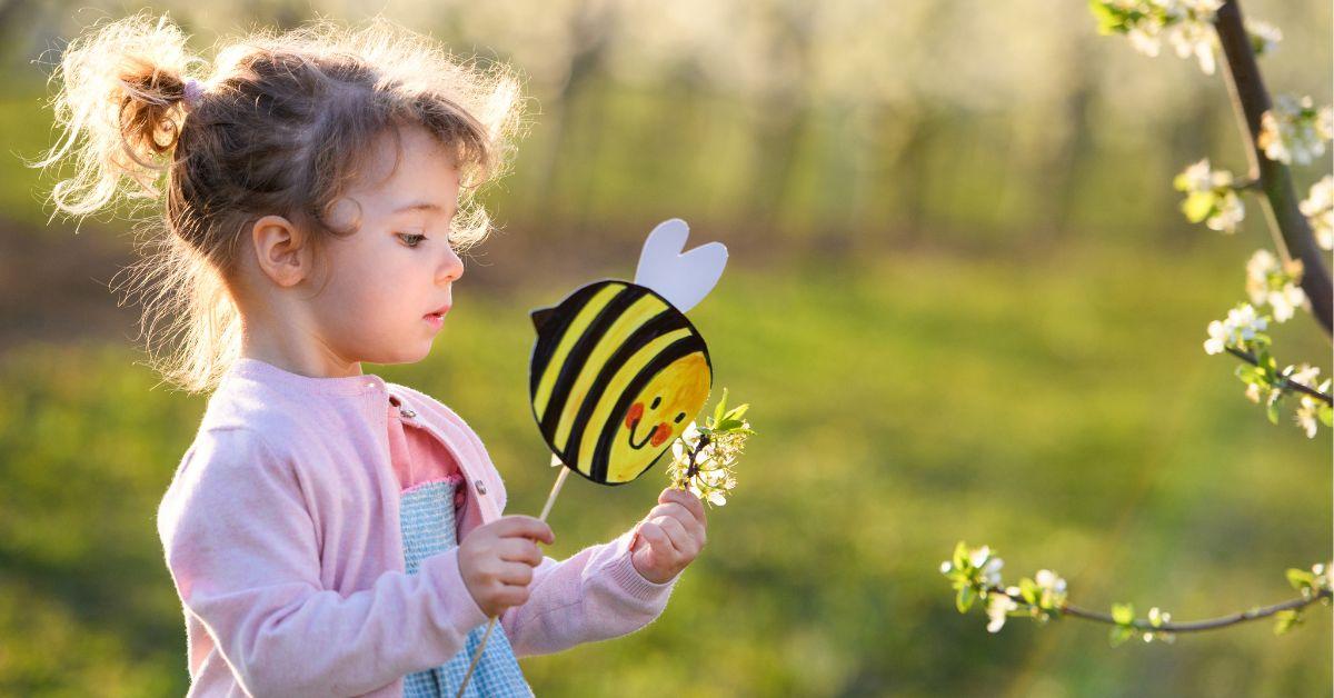 Small toddler girl standing outdoors in orchard in spring