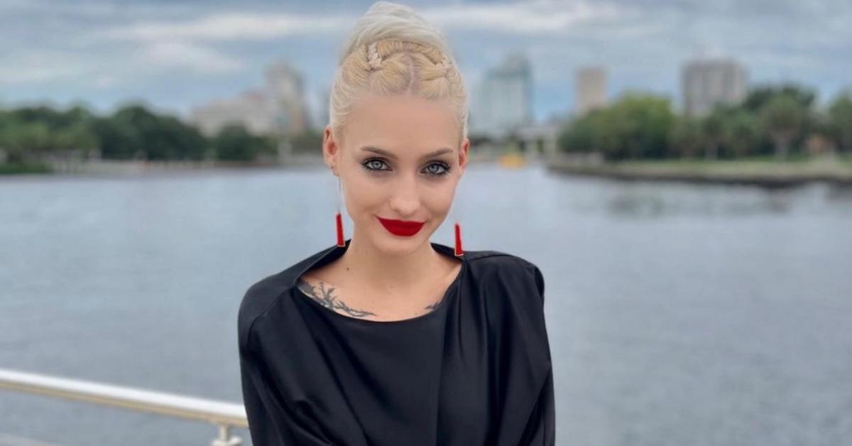 Moriah Plath on a boat with red lipstick and a black dress.