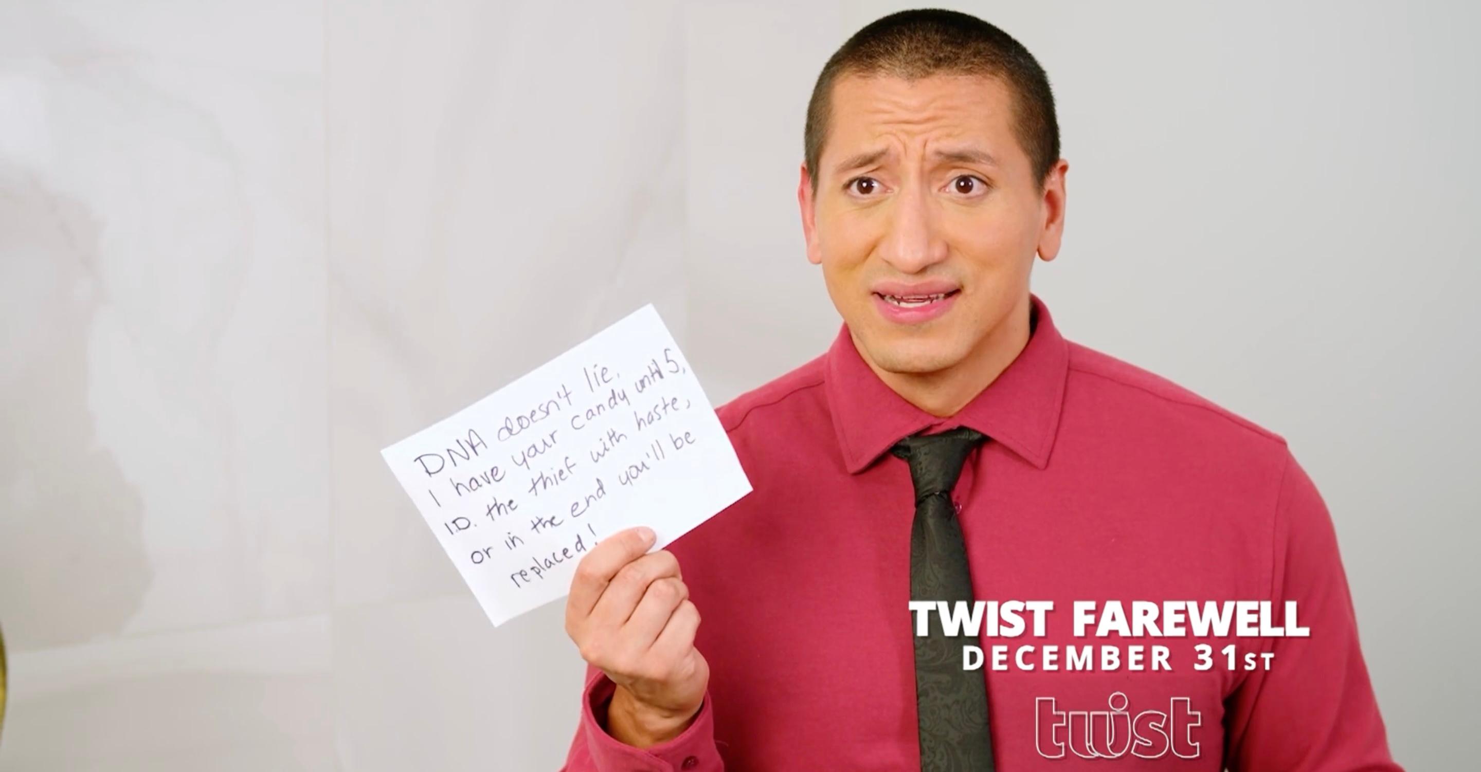 A man in a red shirt holding a piece of paper