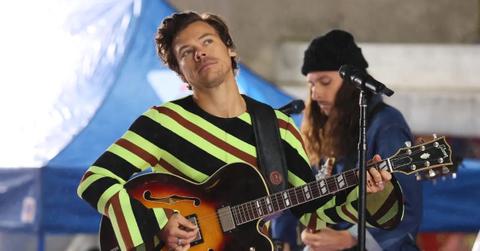 Harry Styles performing in a striped shirt.