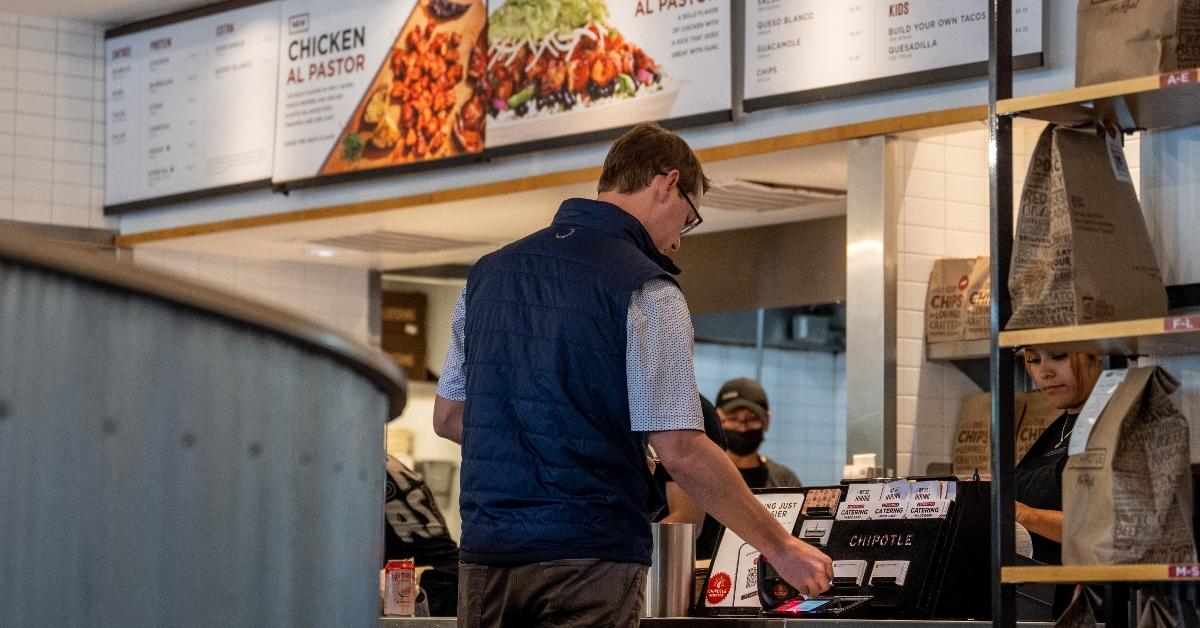 Man stands in front of a Chipotle checkout