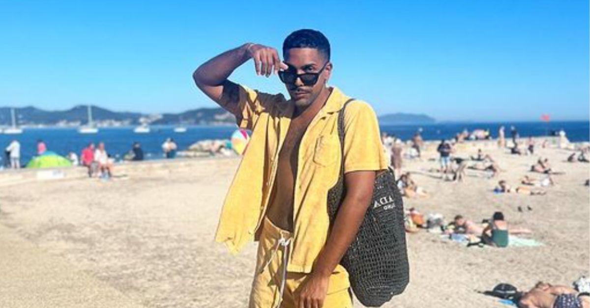 Johnathan Shillingfod poses in yellow matching wet on the beach