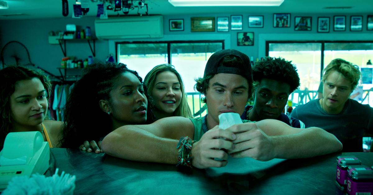 (L-R) Kie, Cleo, Sarah, John B., Pope, and JJ looking at their bank statement in Season 4 of 'Outer Banks.'