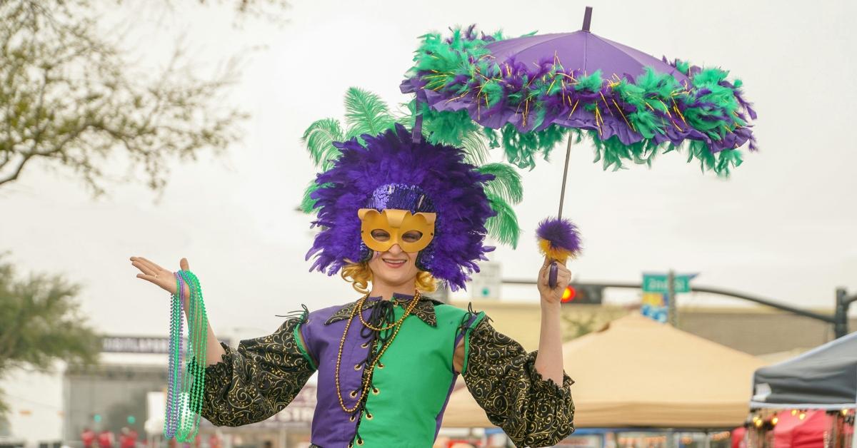 Mardi Gras attendee holds up beaded necklaces