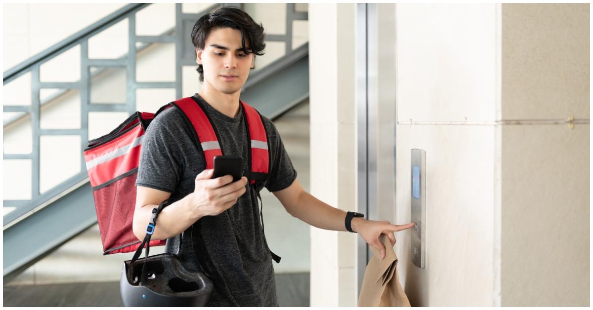 A food delivery driver looking at his phone