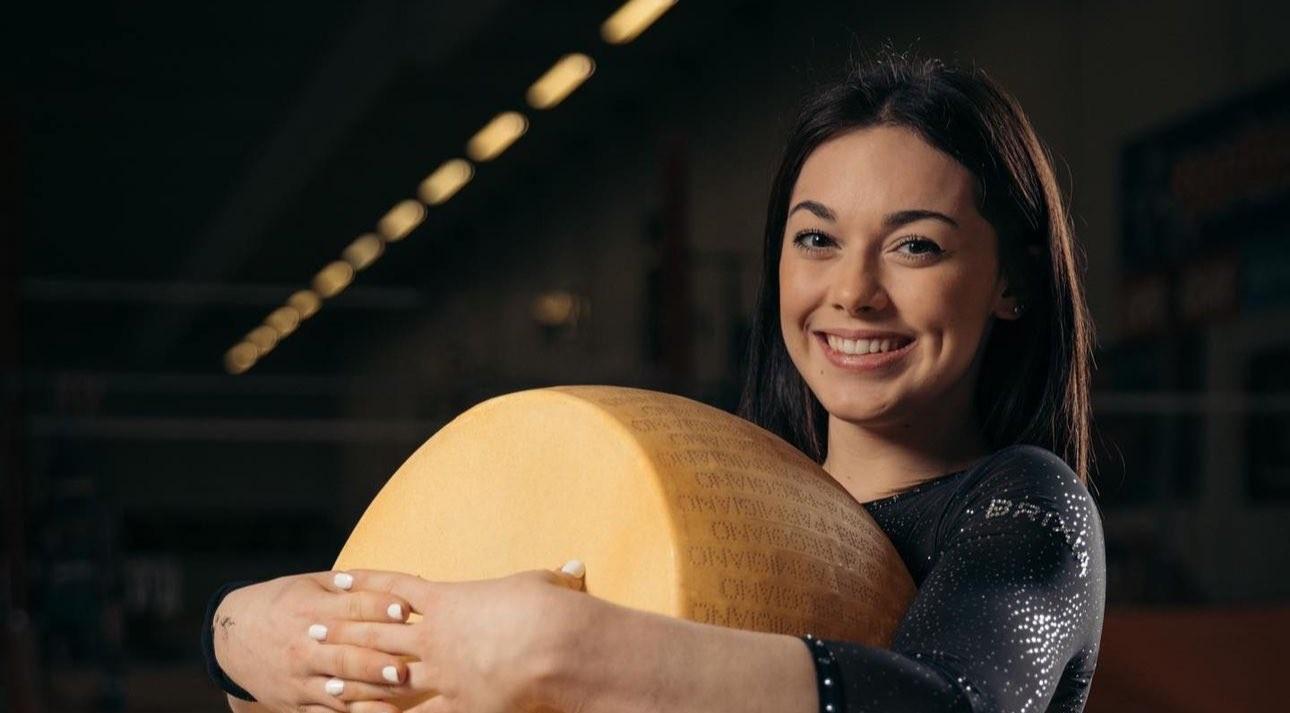 Giorgia Villa holding a big wheel of parmesan