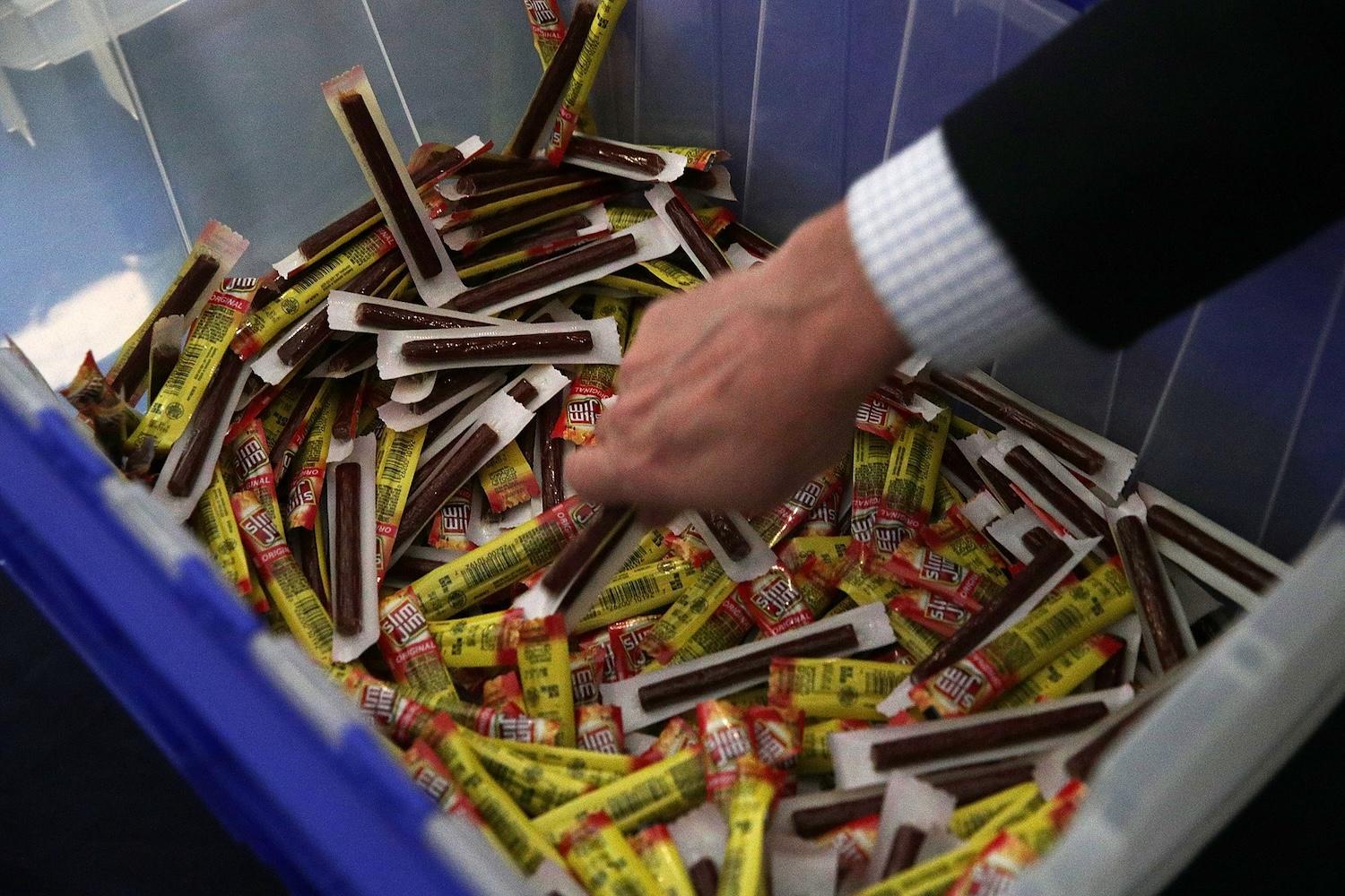 A person reaching into a box of Slim Jims