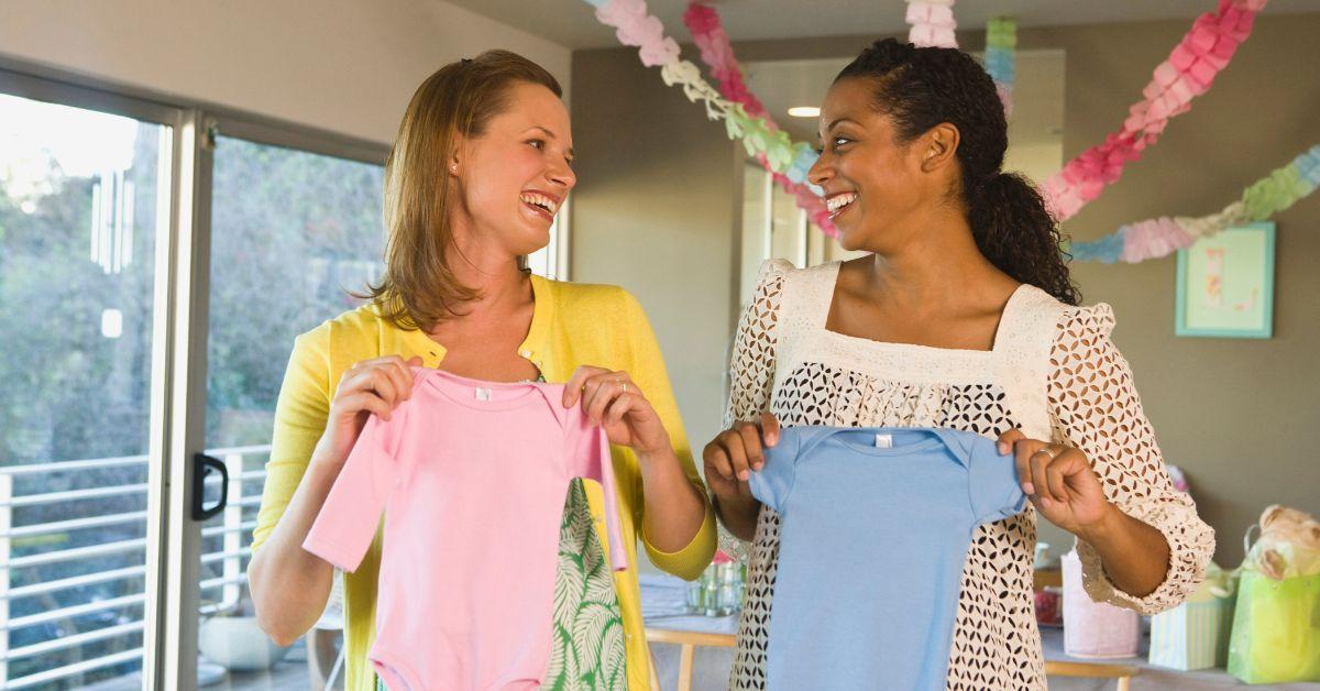 women holding baby clothes