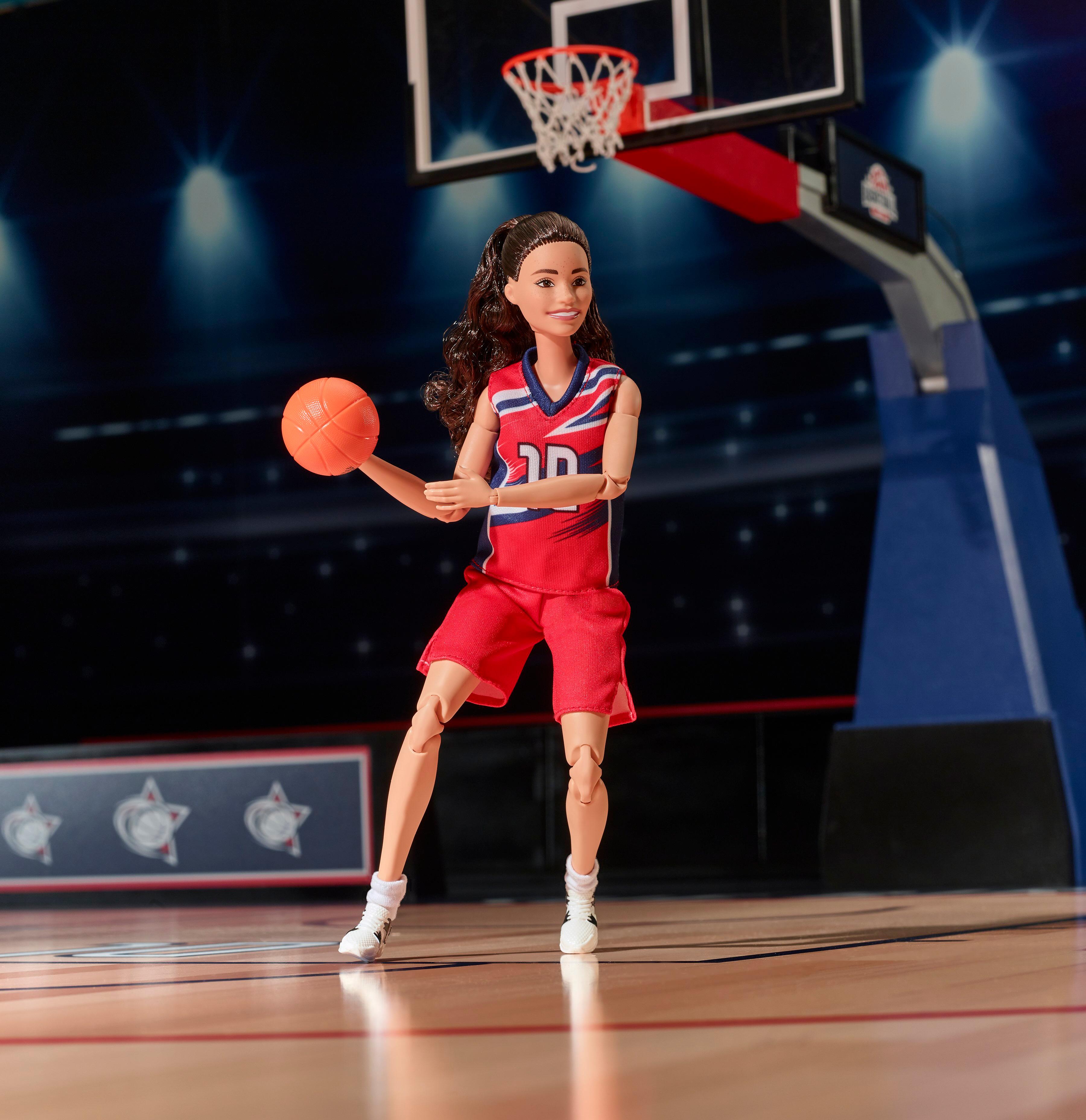 Sue Bird's Barbie role model doll playing basketball on the court.