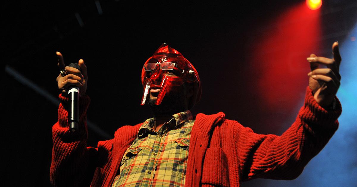 MF Doom performing on stage in a red mask. 