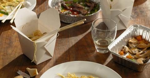 Half-eaten Chinese takeout dinner - stock photo