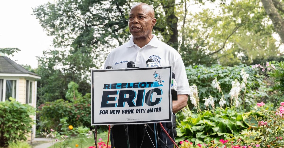 Mayor Eric Adams stands behind a "Re-Elect Eric For New York City Mayor" podium