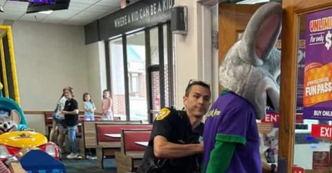 Photograph of man in a Chuck E. Cheese costume being arrested