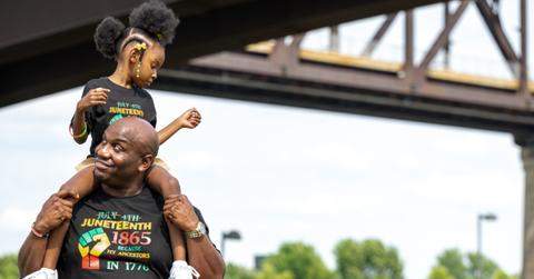A young girl sits on a man's shoulders during the Louisville Juneteenth Festival at the Big Four Lawn on June 19, 2021 in Louisville, Kentucky.