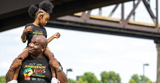 A young girl sits on a man's shoulders during the Louisville Juneteenth Festival at the Big Four Lawn on June 19, 2021 in Louisville, Kentucky.