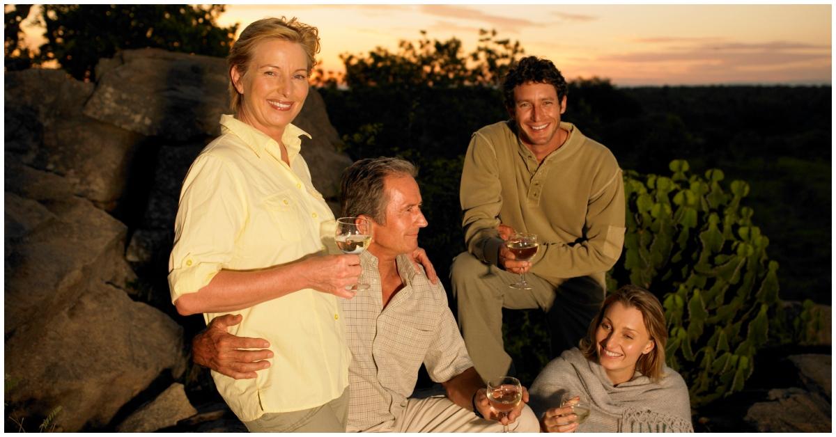 Two couples outside enjoying a glass of wine