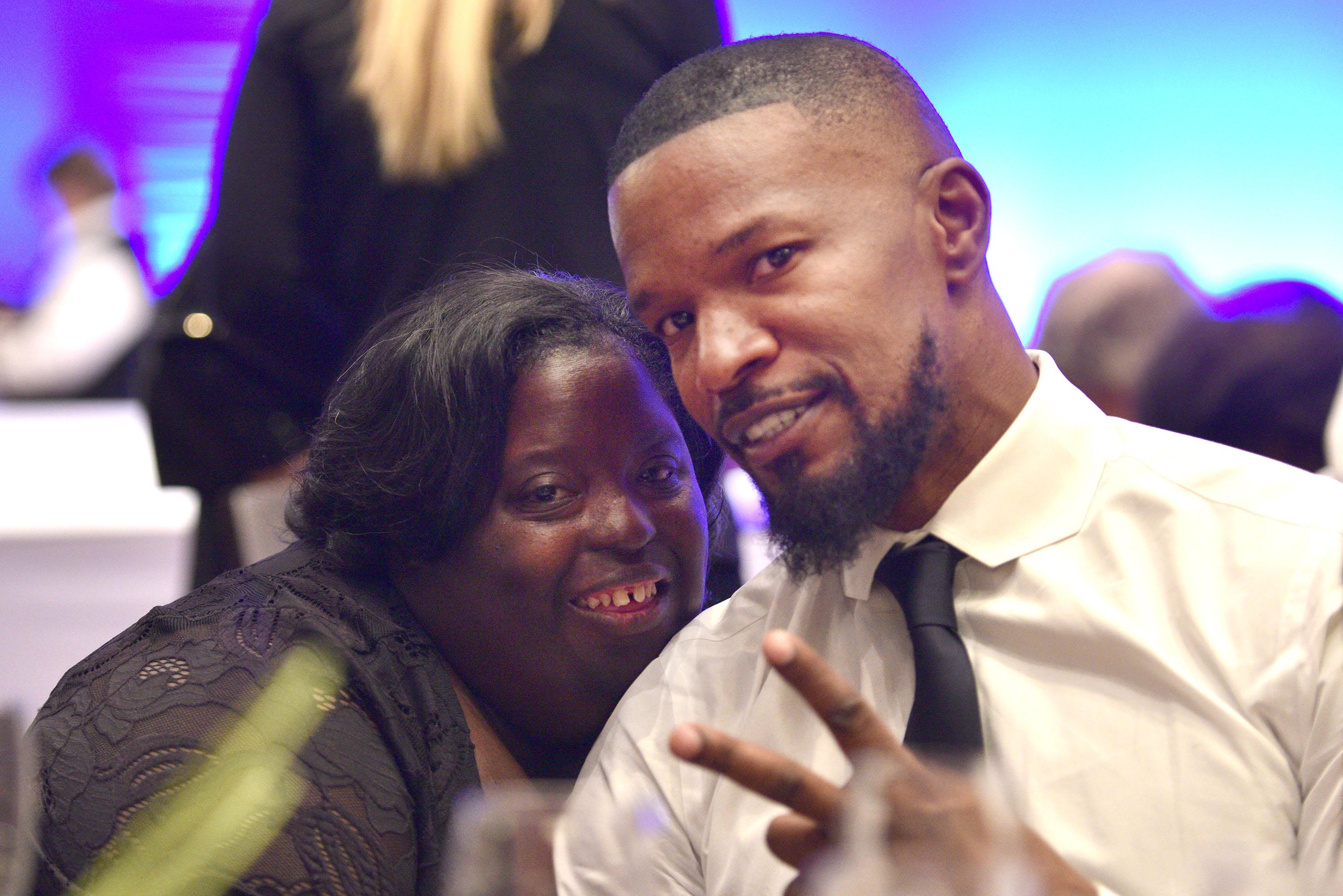 Jamie Foxx flashes a peace sign while posing with DeOndra.