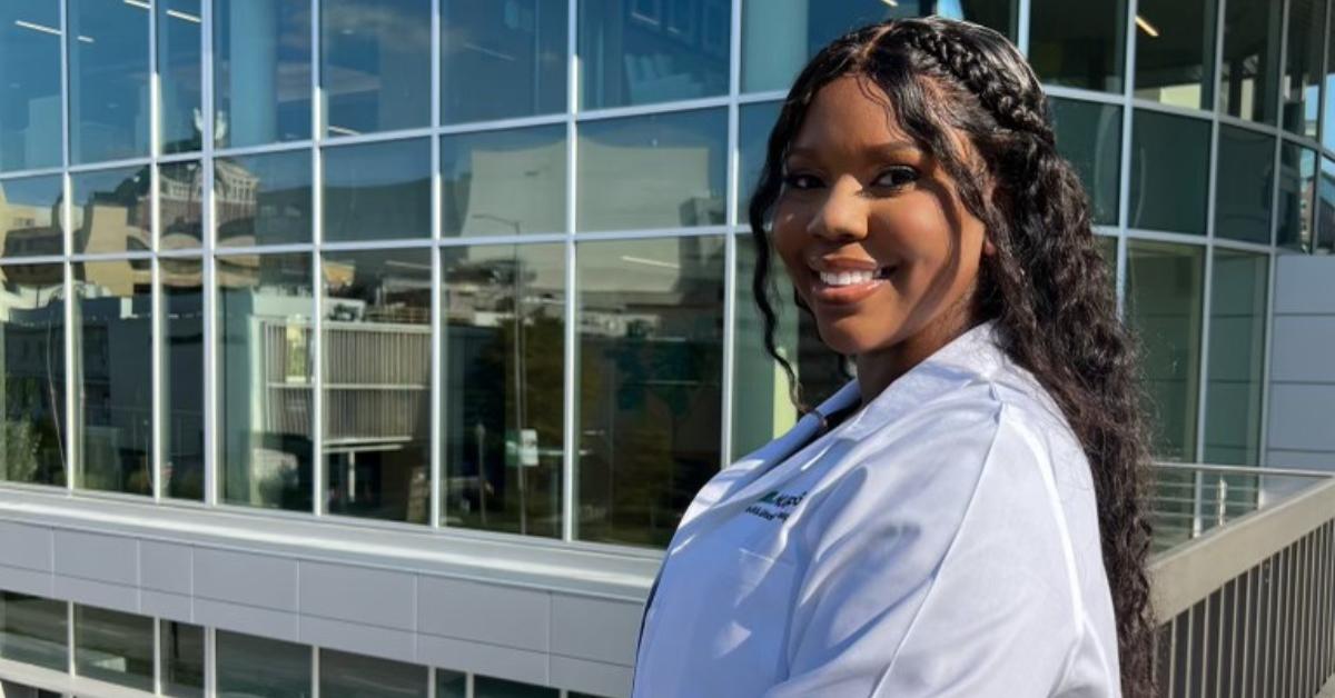 Carlee Poses near library wearing medical white coat.