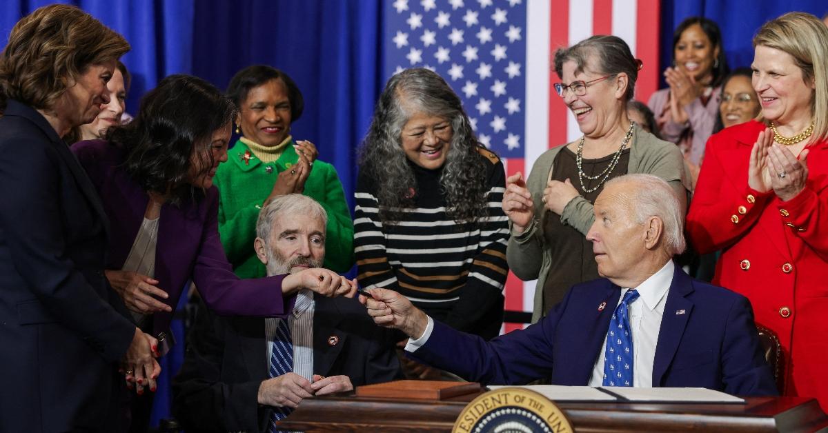 President Joe Biden gifts a pen to acting US Secretary of Labor Julie Su