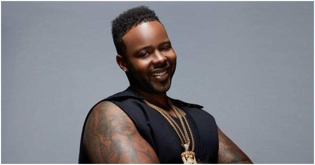 Teddy from 'Black Ink Crew' folding his arms and smiling.