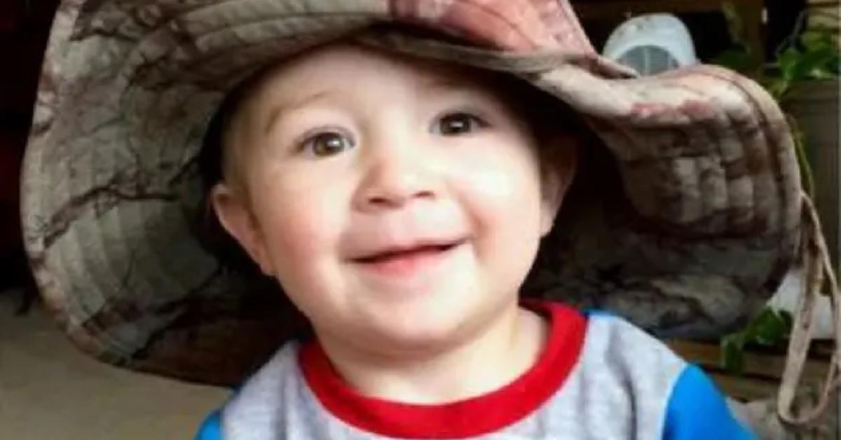 Baby DeOrr wearing a camouflage hat and a Spiderman shirt.