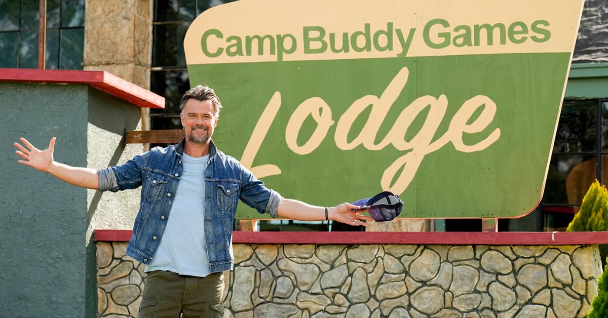 Josh Duhamel standing in front of the 'Buddy Games' lodge sign