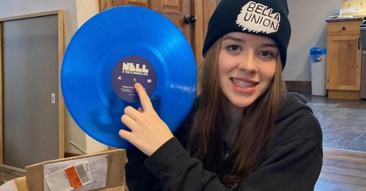 Nell Smith holding up a record with her name on it.