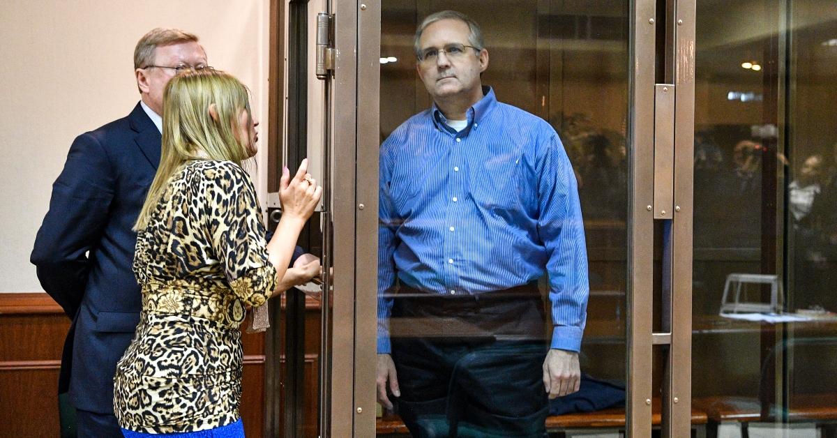 Paul Whelan listens to his lawyers while standing inside a defendants' cage.