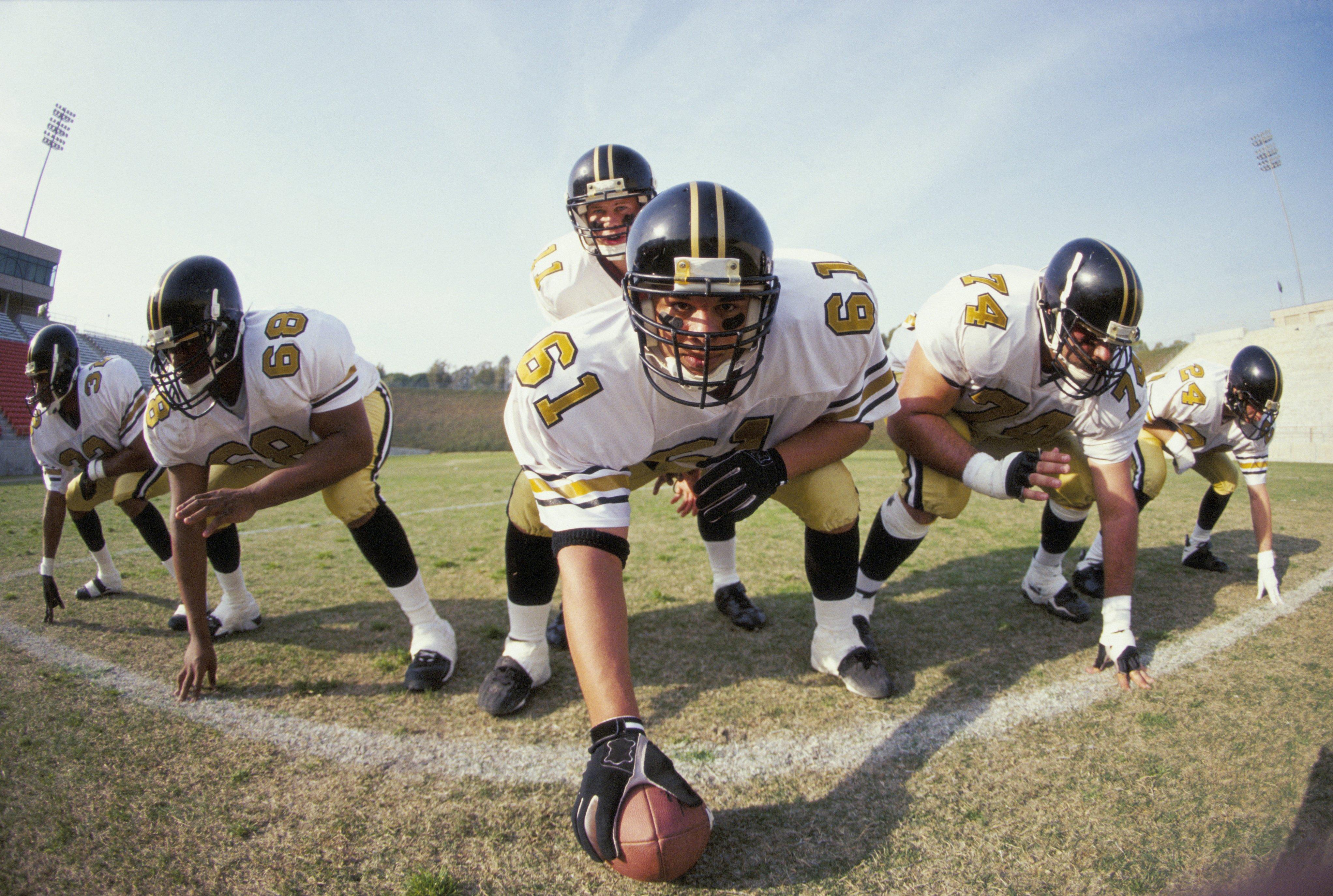 The center prepares to snap the ball to the quarterback.