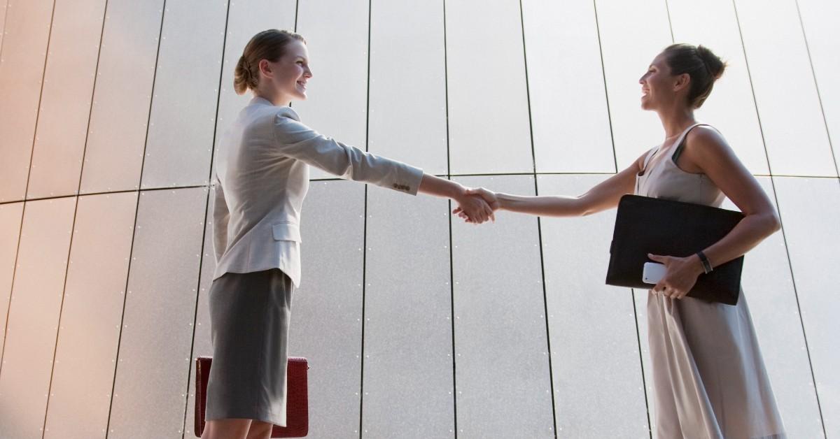 Two female business colleagues shake hands. 
