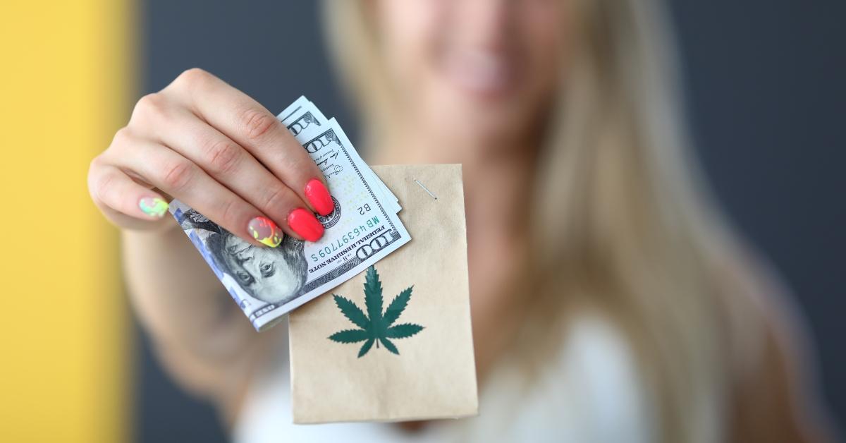 Woman holding package with marijuana and money