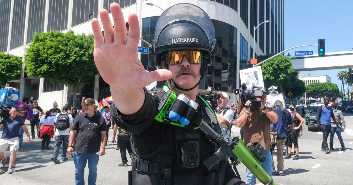 A police officer raising his hand to a person.
