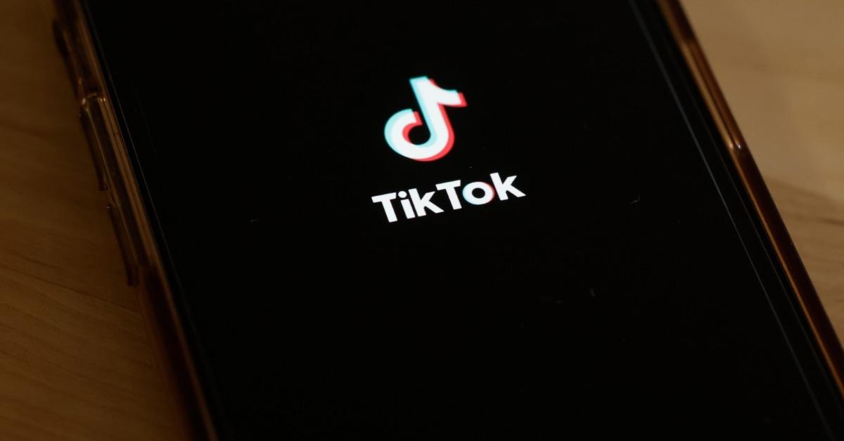 The TikTok logo on a black phone screen. 