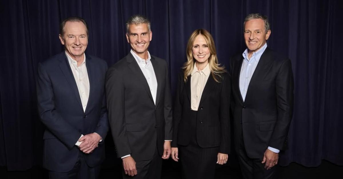 (l-r): A Disney executive, Josh D'Amaro, Dana Walden, and Bob Iger smiling