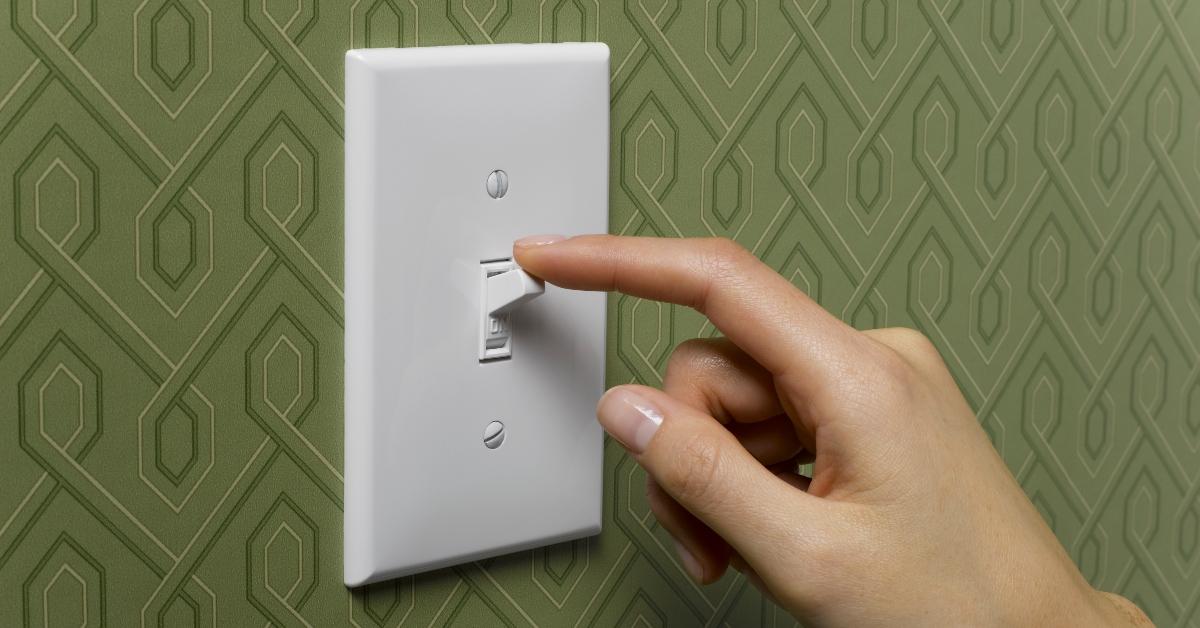 hand flicks light switch to the "off" position