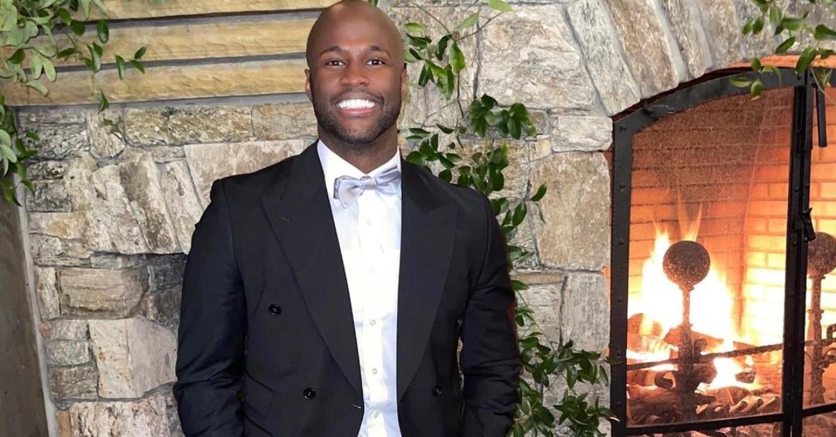 Nehemiah Lawson in front of a crackling fire in a tuxedo