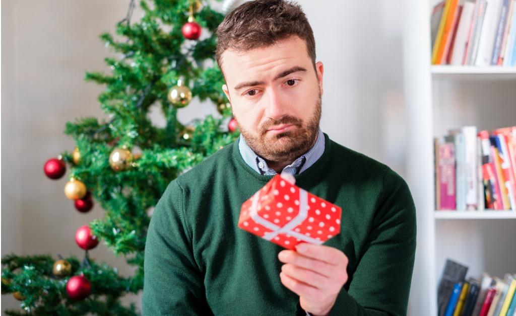 funny face of a man disappointed by the small gift box picture id