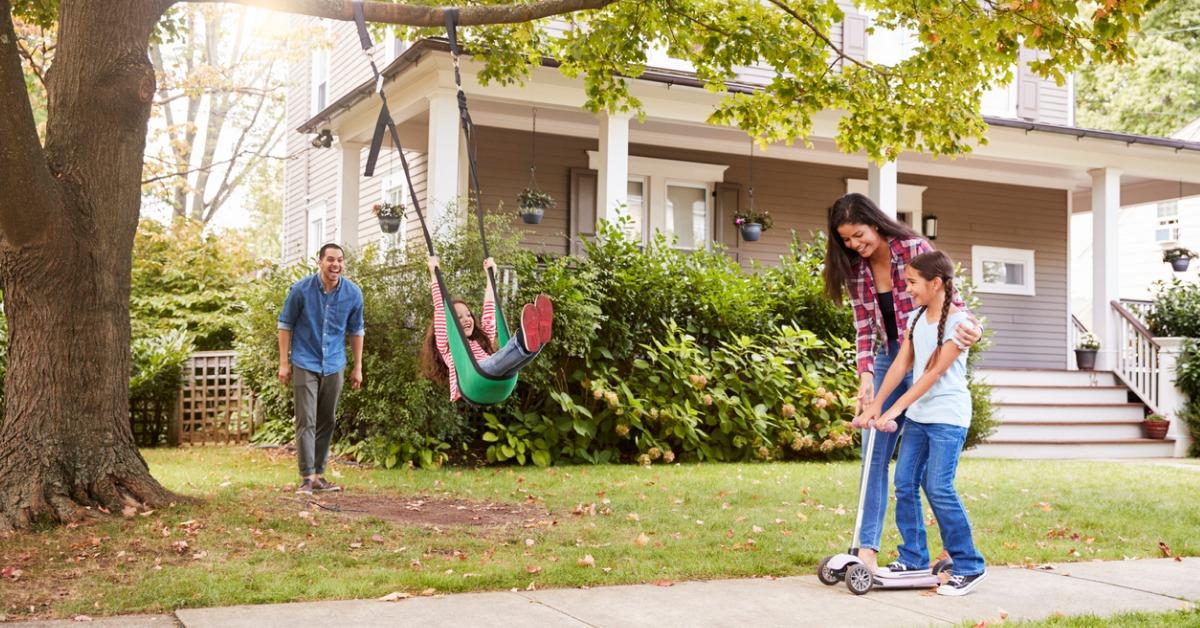 children playing on garden swing and scooter outside house picture id