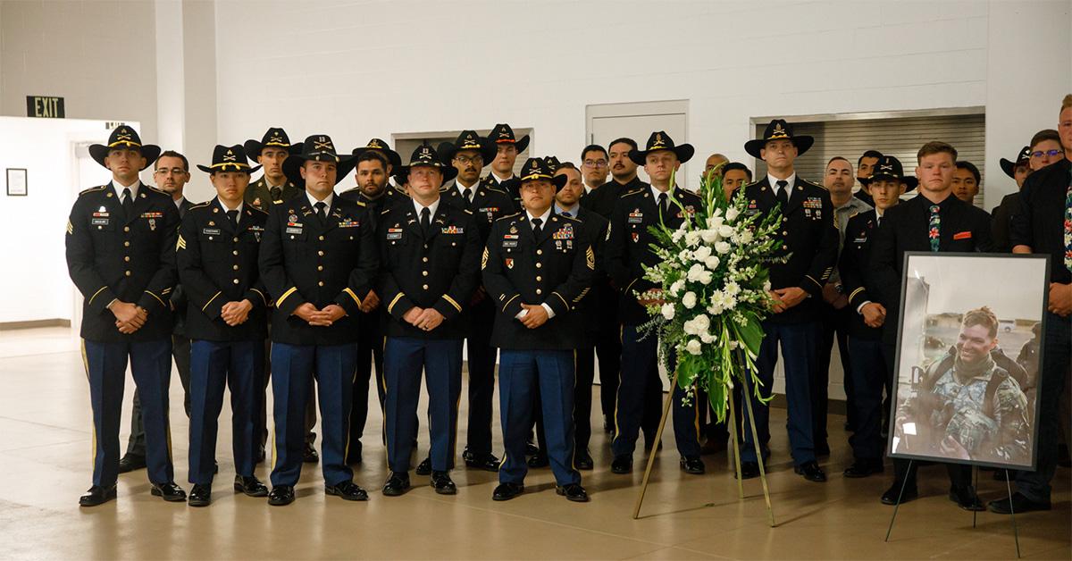 Garrison Brown's family and colleagues pose for a photo with his photo. 