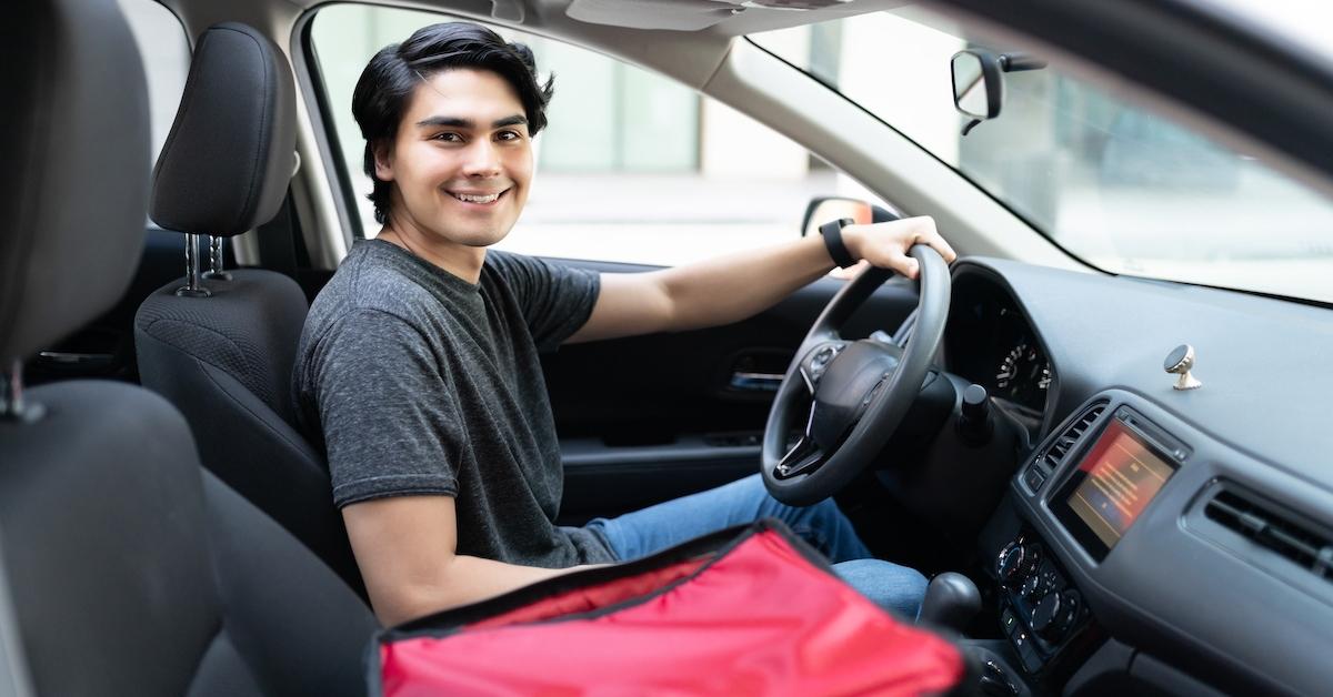 A DoorDash delivery driver in his car