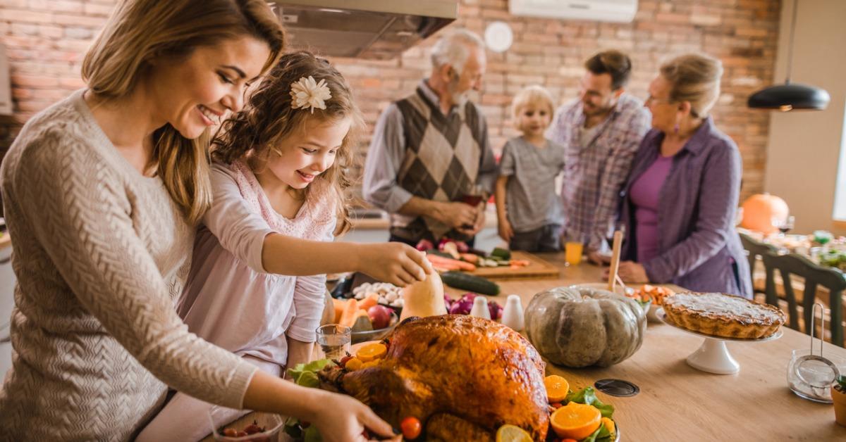 happy mother and daughter preparing roasted turkey for thanksgiving picture id