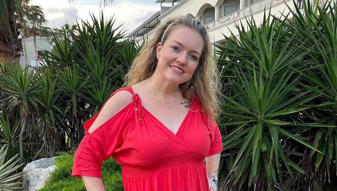 Colleen Hoover wearing a red outfit.