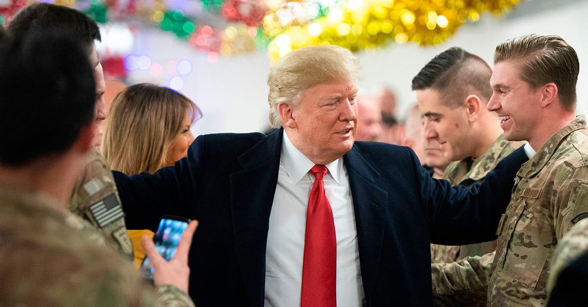 Donald Trump with his hands on the shoulder of troops. 