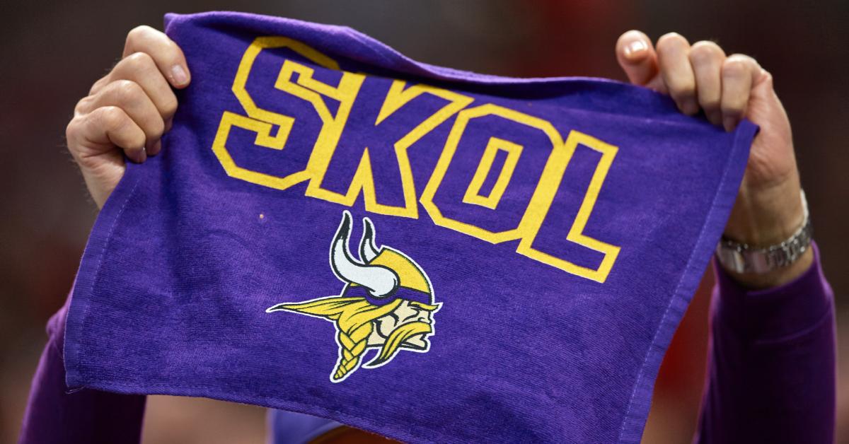 Minnesota Vikings fan hold up a towel that says, "Skol!"