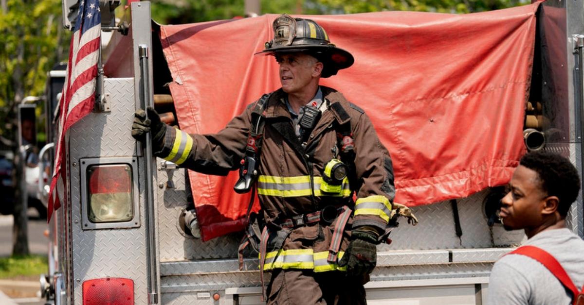 Herrmann standing on the back of a firetruck.