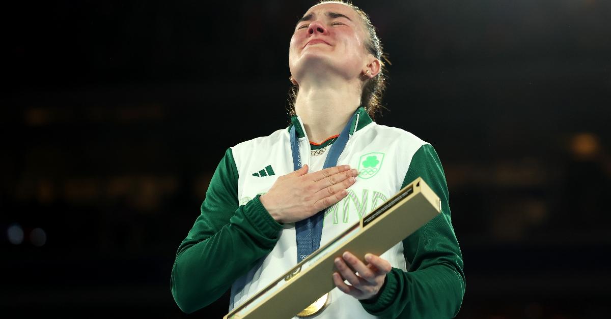 Gold Medalist Kellie Harrington of Team Ireland celebrates on the podium during the Women's 60kg Boxing medal ceremony after the Women's 60kg Final match on day eleven of the Olympic Games Paris 2024 at Roland Garros on August 06, 2024 in Paris, France. (Photo by Richard Pelham/Getty Images)