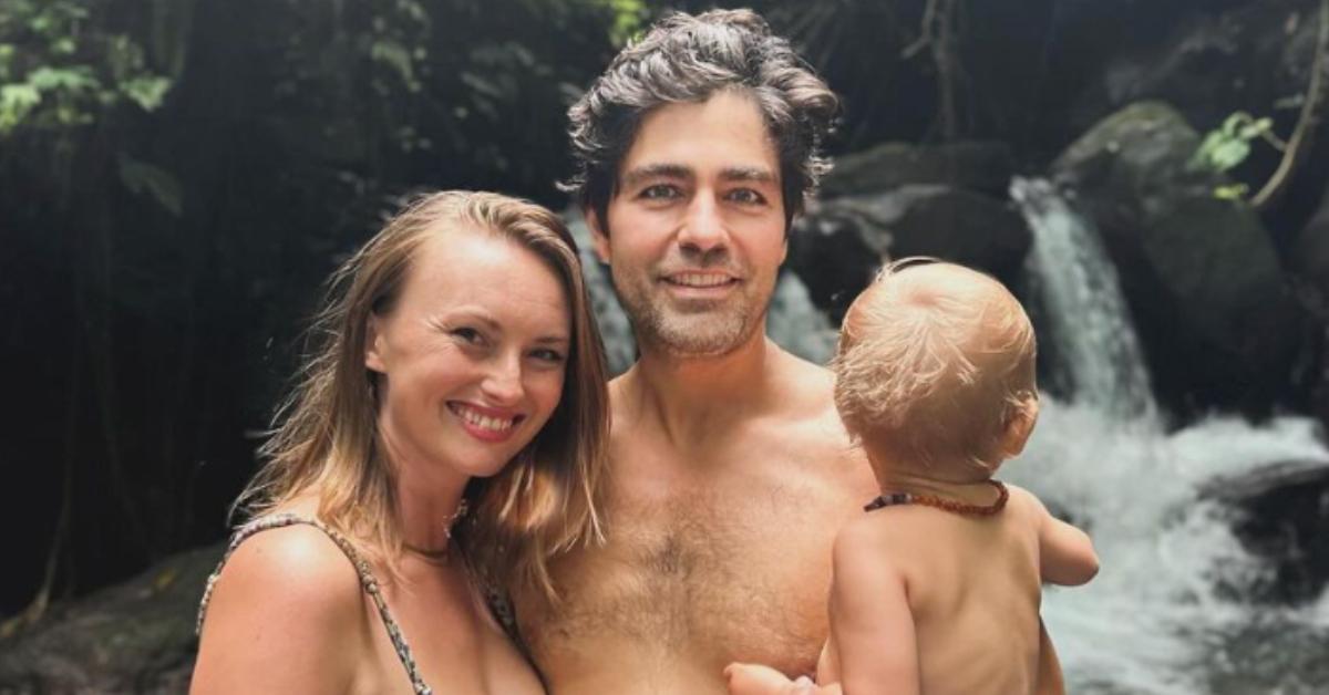 Adrian Grenier poses with his wife, Jordan, and their son in front of a water fall