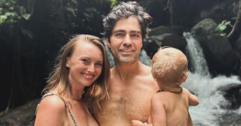 Adrian Grenier poses with his wife, Jordan, and their son in front of a water fall