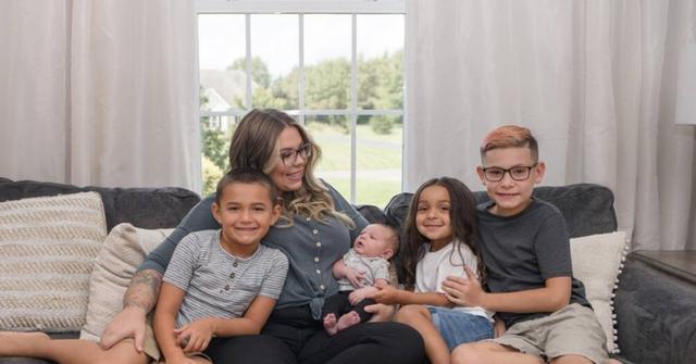 Kailyn posing with all the. boys for a family photo.