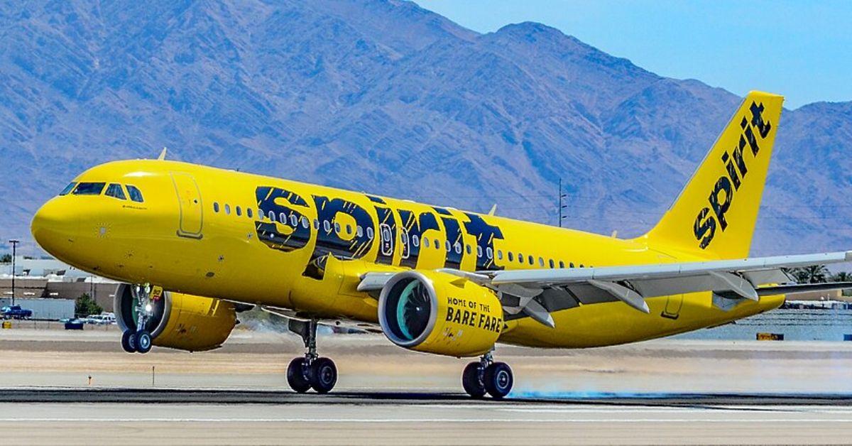 A Spirit Airlines plane taking off from a runway. 